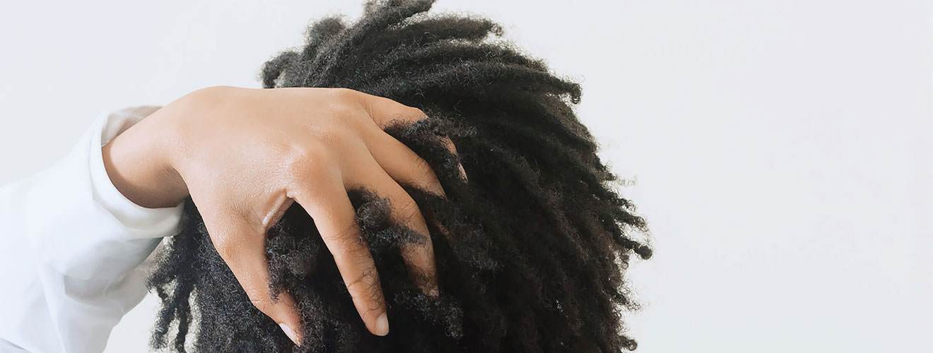 Young black woman with natural hair running her hand through her hair