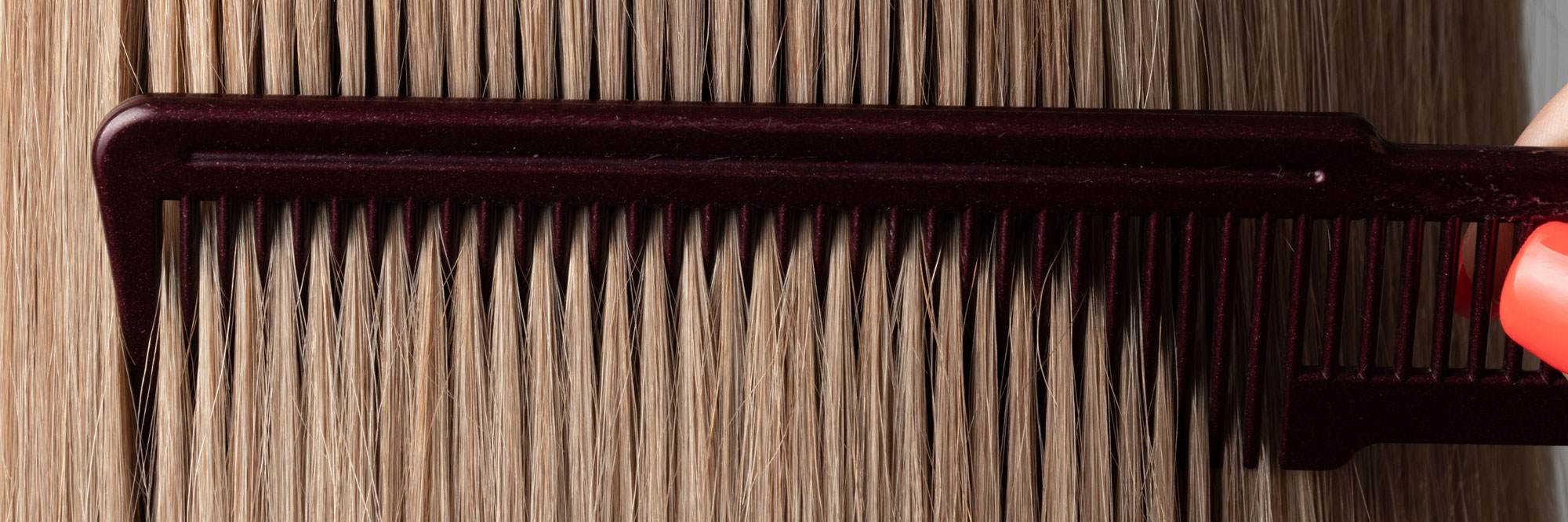Close up on a comb going through blonde straight hair