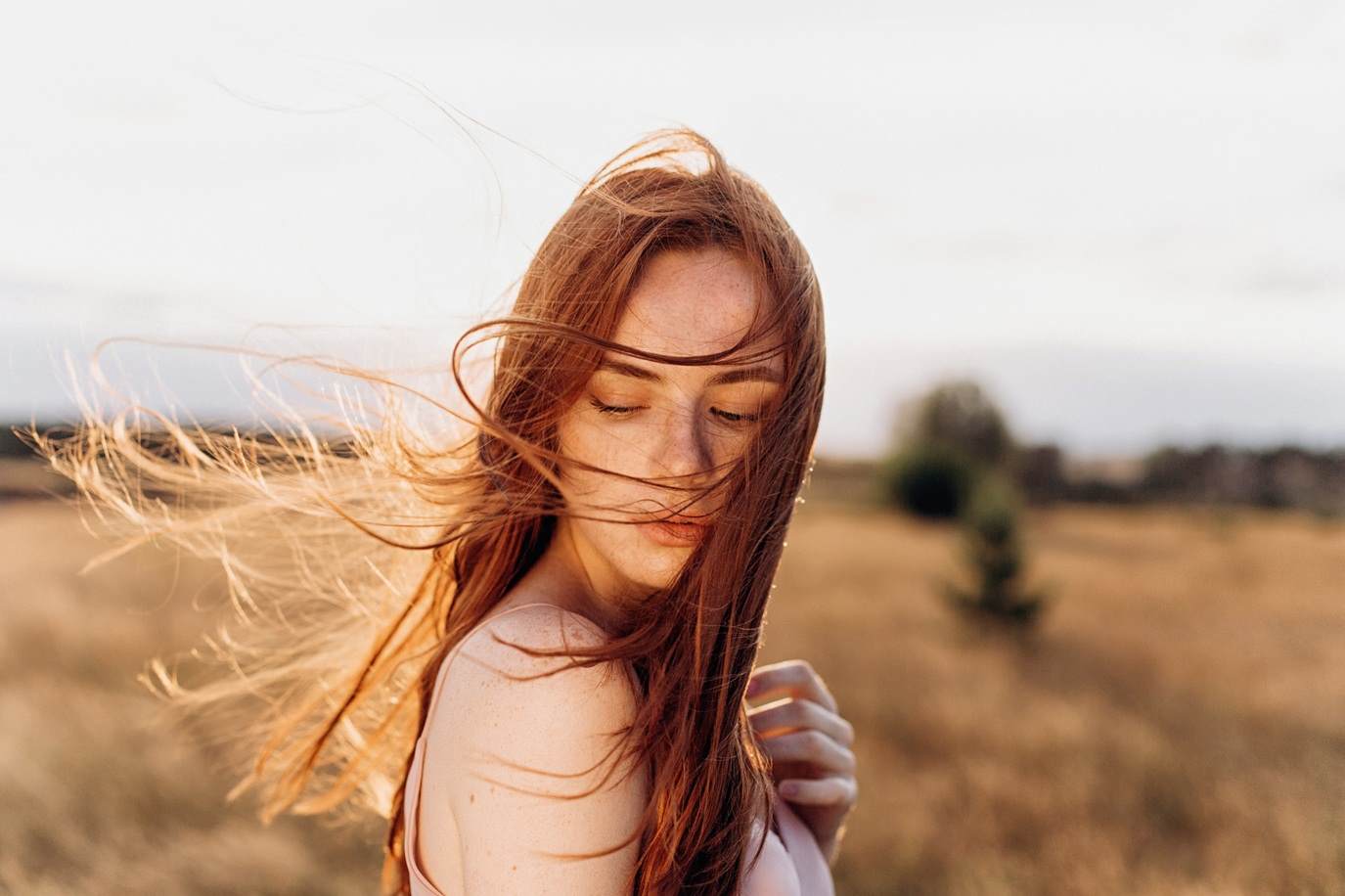 Hair care Woman with hair blowing in the wind landscape 1 female white red hair care 