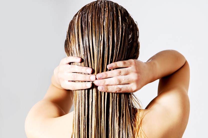 Oils in hair care Applying hair mask back of the head landscape 1 female white blonde hair care