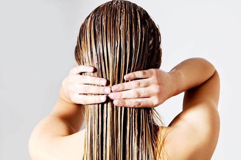 Oils in hair care Applying hair mask back of the head landscape 1 female white blonde hair care