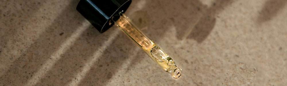 Cropped image of a pipette filled with a golden fluid.