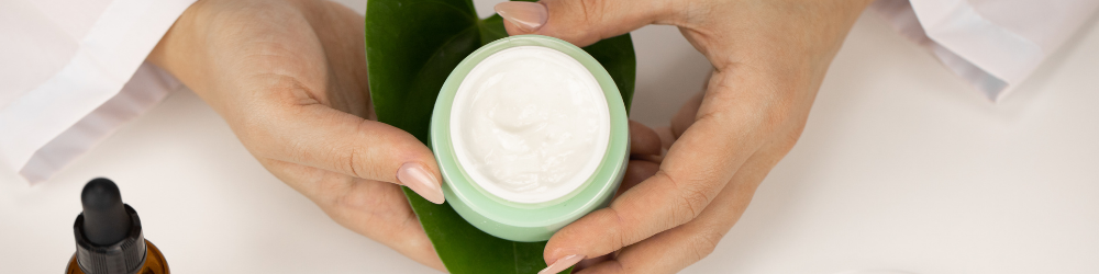 beauty formulator holding pot of cream in hands