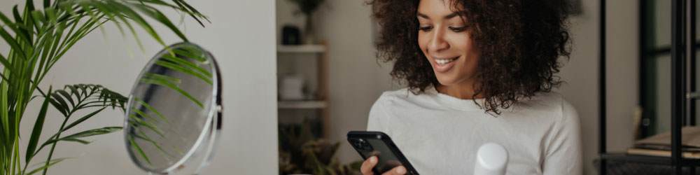 woman on her phone and looking at beauty products