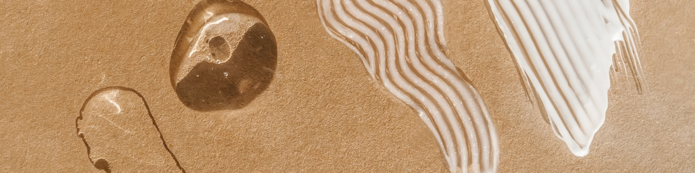 different sun care formulation textures on a sand background including gels, serum and creams