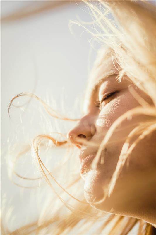 sunscreen formulation strategies to maximise skin protection white women with eyes shut blonde hair blowing around face