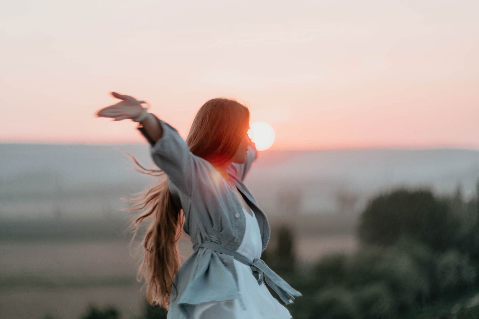women in with hands up in the air on a summers evening 