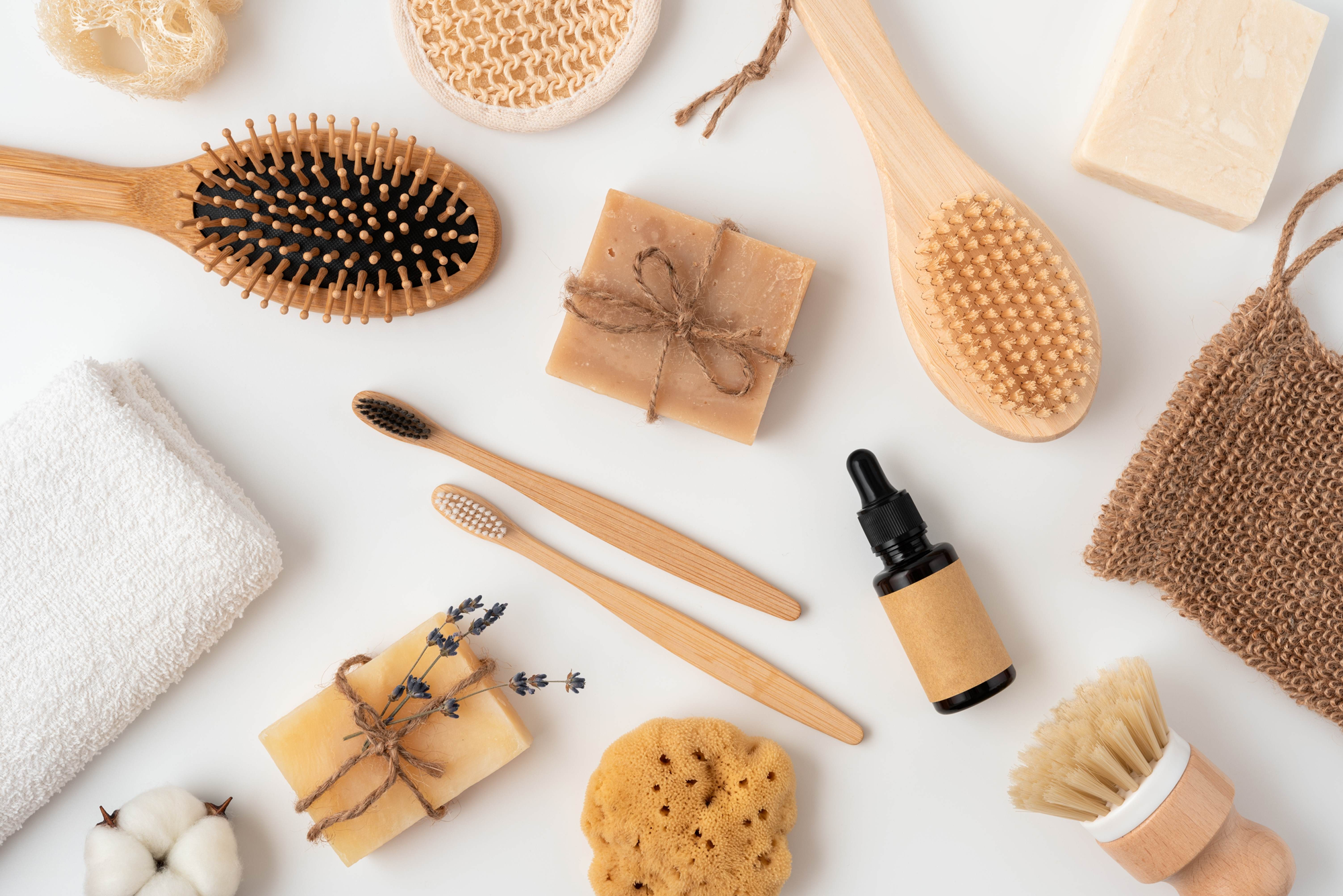 A selection of objects associated with beauty and grooming arranged on a white background. We can see brushes, soap, serums, wipes and sponges.