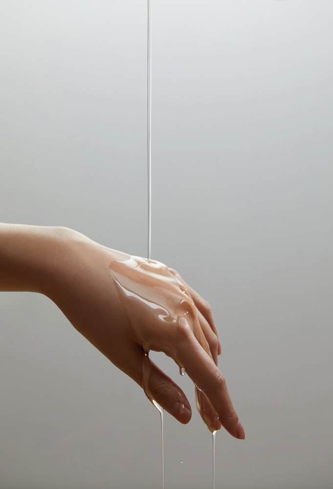 Gel dripping over a white woman's hand