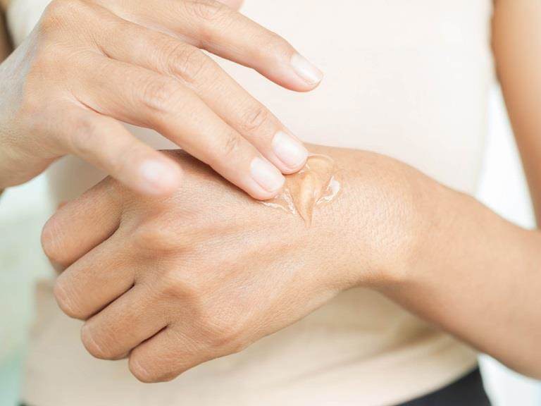 Cropped photos of a white woman's hands. She is applying a serum to her hands.