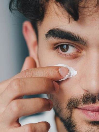 Male applying skin product to face