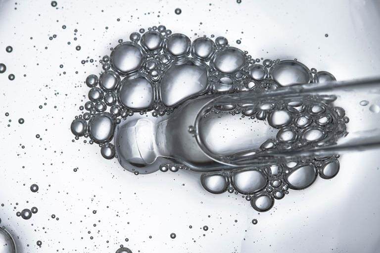 peptides Dropper with bubbles close-up top view landscape skin care actives
