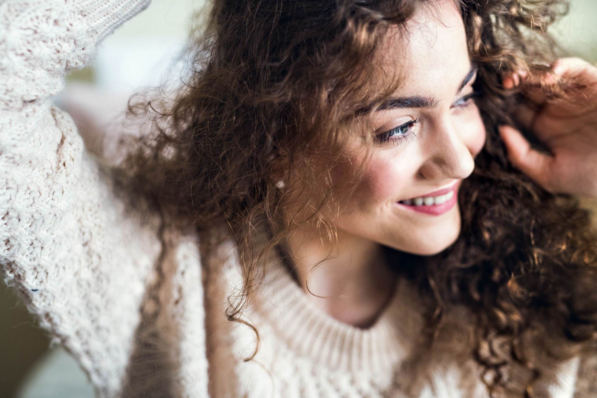 Girl touching her scalp with curly hair