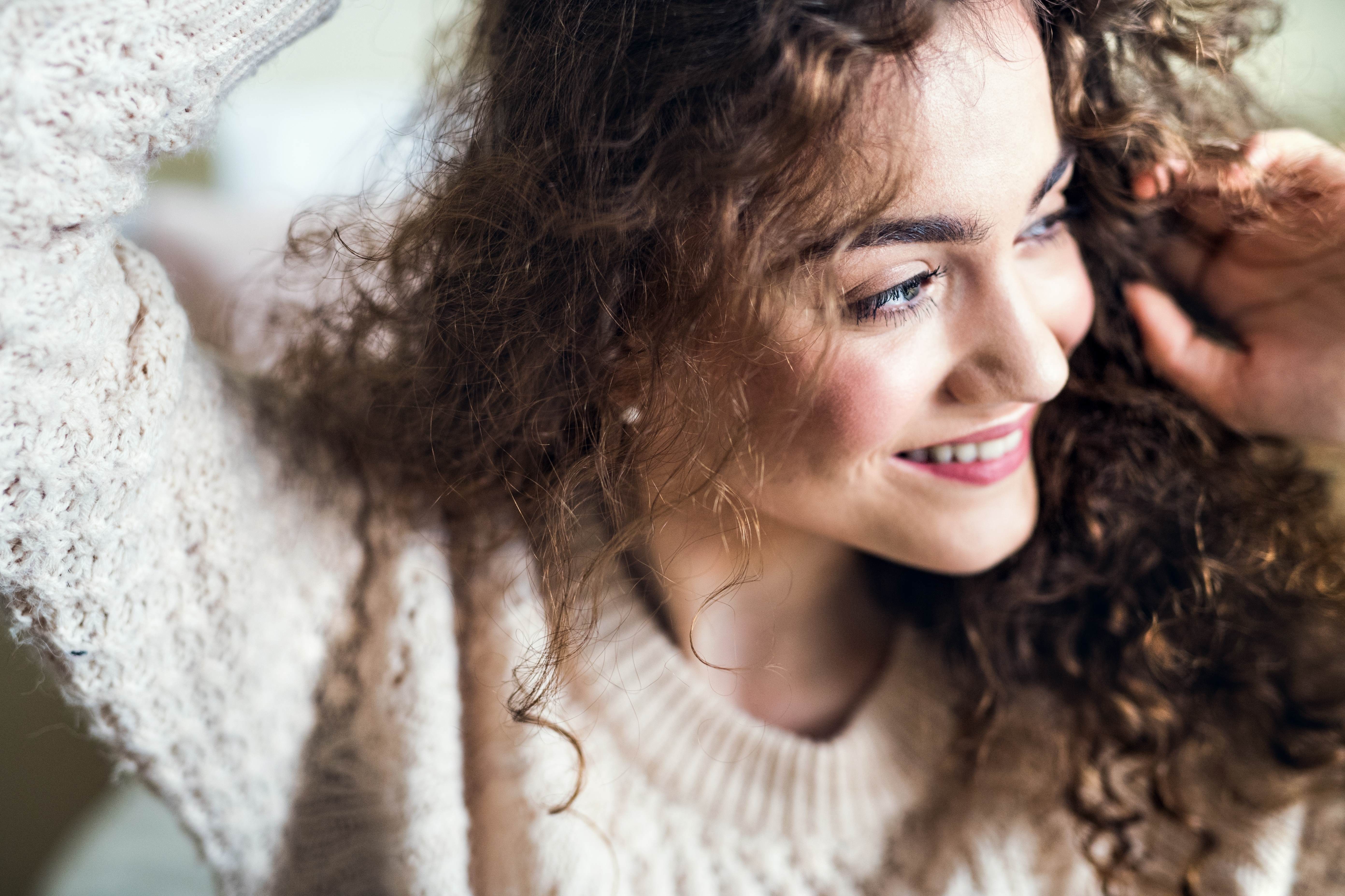 Girl touching her scalp with curly hair