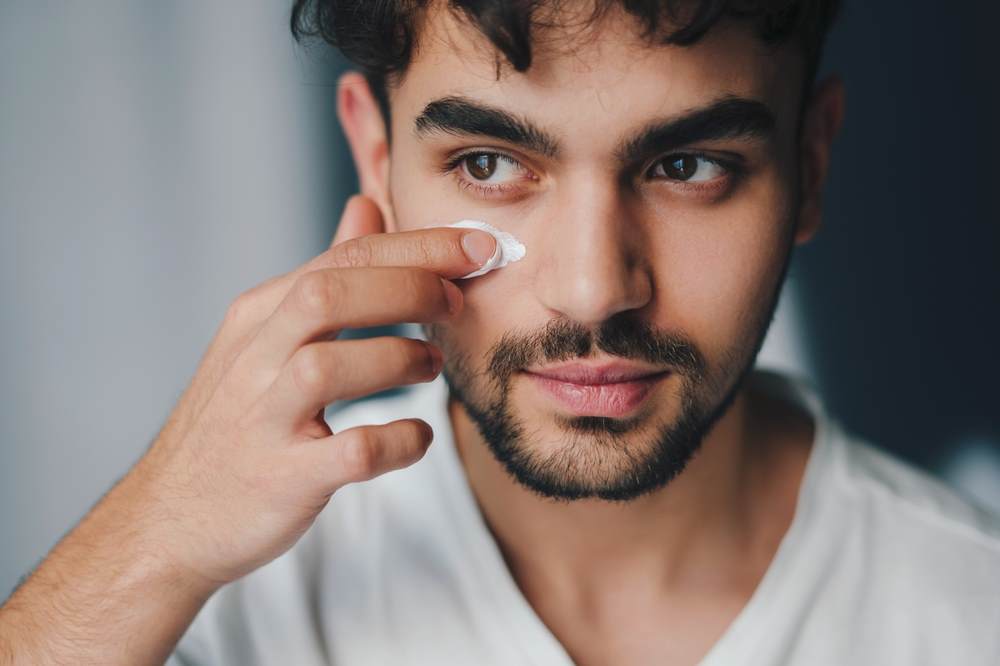Man putting face lotion on 