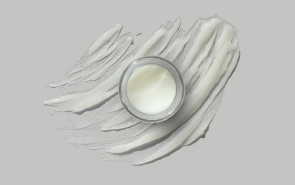 Infinite balm formulation in a jar with the balm spread behind it