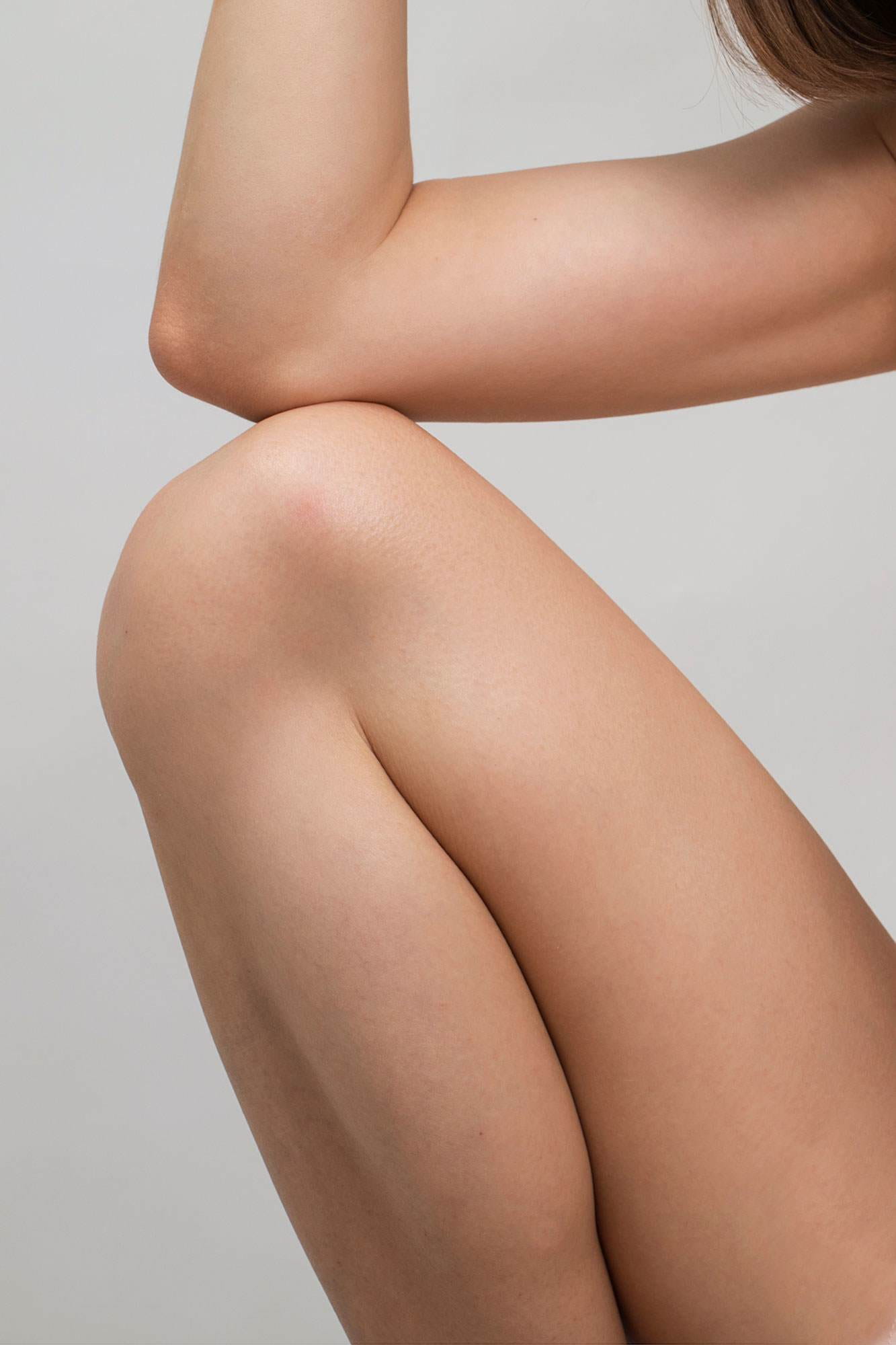 Cropped image showing a white woman's knees and elbows