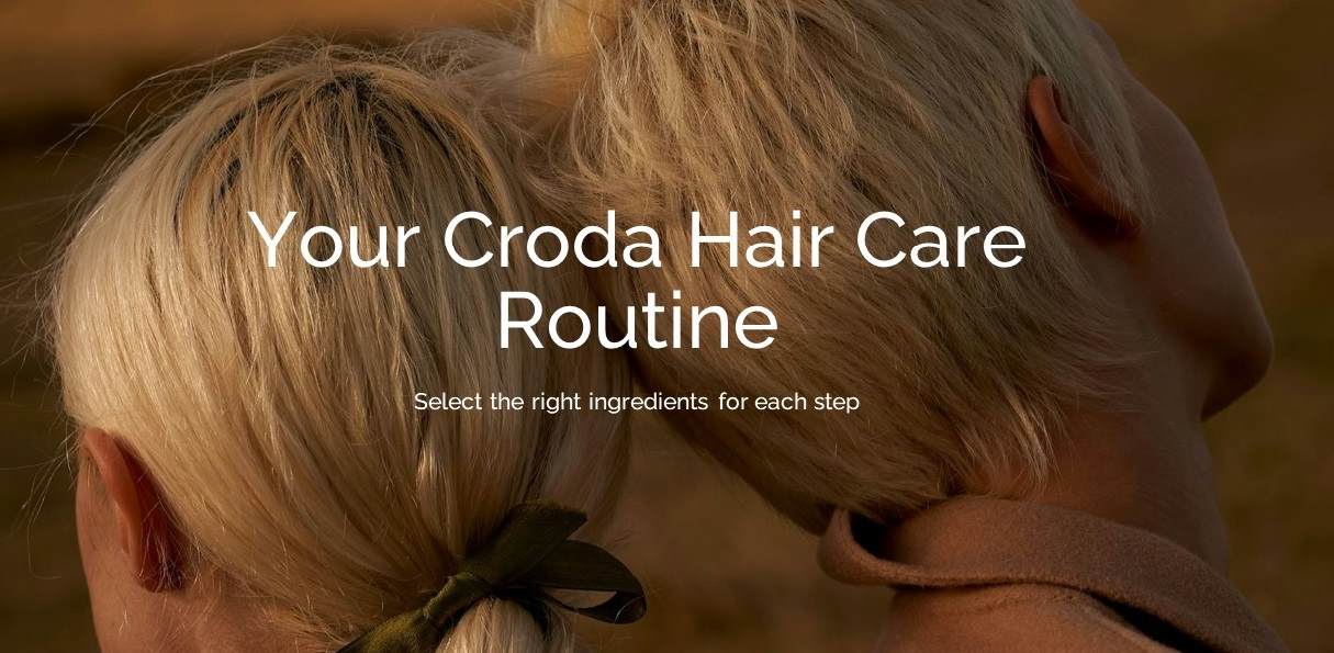 2 blond people standing back to back, their heads touching.