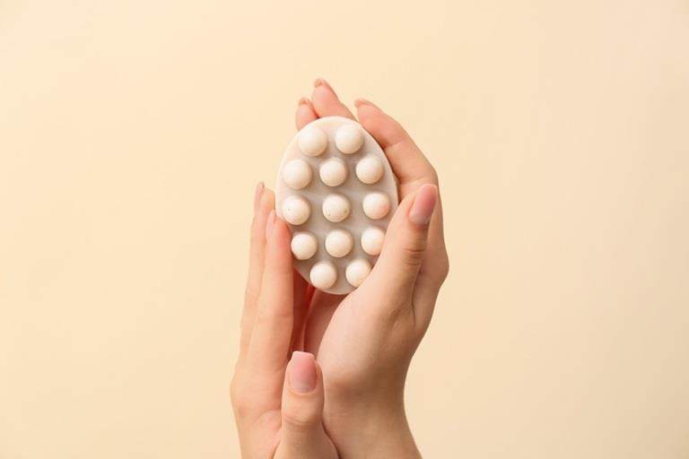 2 hands holding up a massage bar