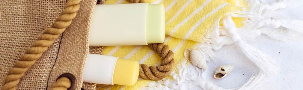 Stick format sunscreen on a beach towel on the beach.