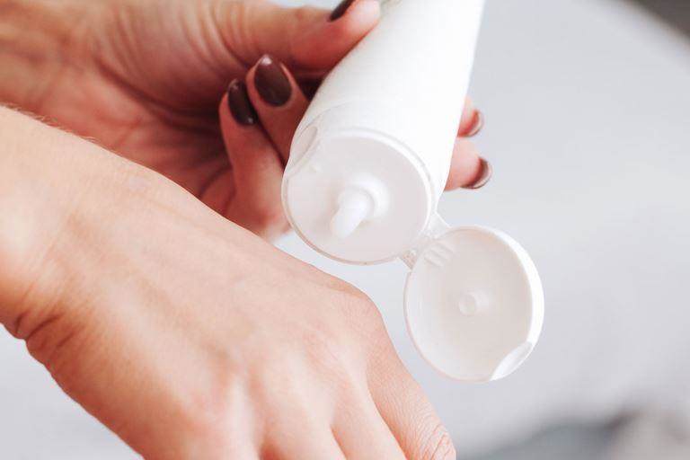 spf boosters - cropped photos showing a white woman applying cream to her hand