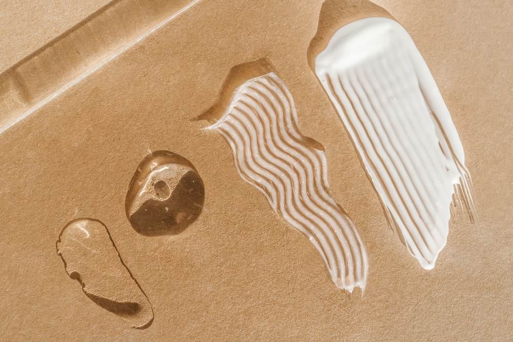 different skin product textures with sand background