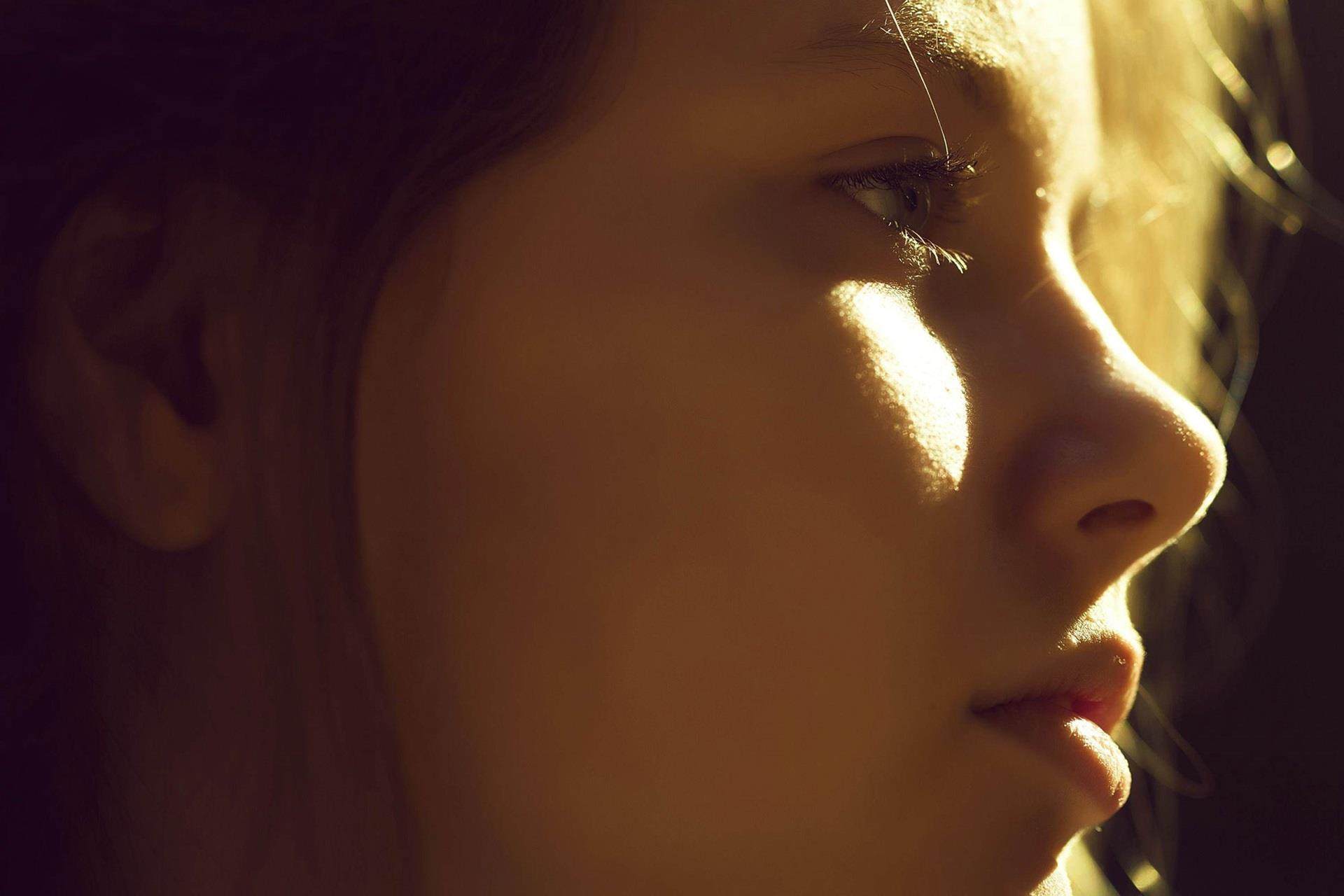 person looking to the side with sun shining on their face